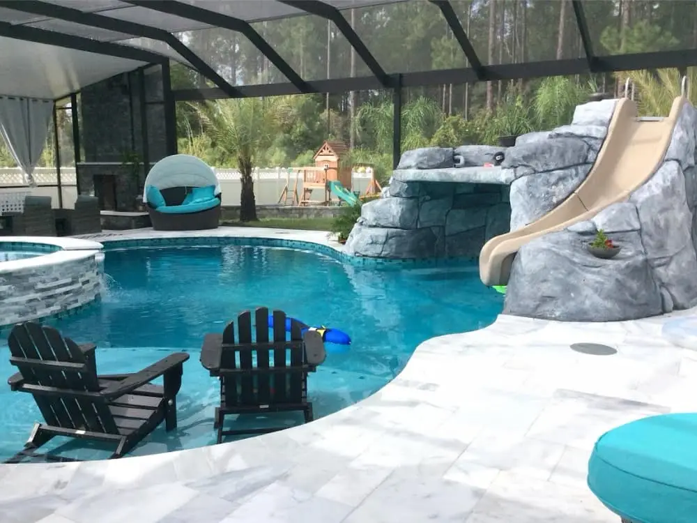 freeform pool, sun shelf, artifical rock waterfall , slide, screen pool enclosure