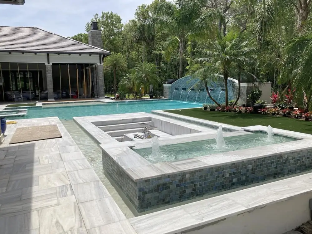 pool, spa, bubblers, raised scupper waterfall, travertine deck, sunken seating, by Holly Hill Pool Builder Agua Pools FL